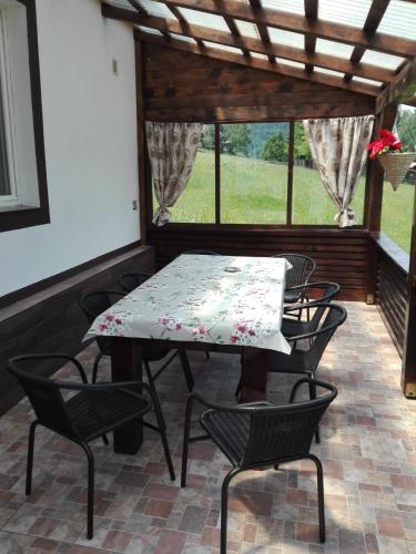 a table and chairs on a screened porch with a table and chairs at Cabana Busuioc in Colibiţa