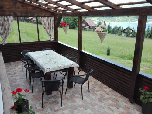 a patio with a table and chairs and a view of a field at Cabana Busuioc in Colibiţa