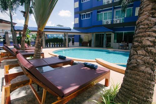 a swimming pool with a table and chairs next to a building at Best Western Royal Buriram in Buriram