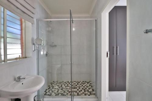 a bathroom with a shower and a sink at Fin and Feather Guest Lodge in Boksburg