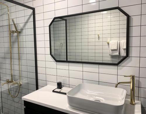 a white sink sitting under a mirror in a bathroom at Fresh Hill in Cheongdo