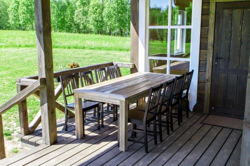 een houten tafel en stoelen op een veranda bij Alkūnų sodyba in Molėtai