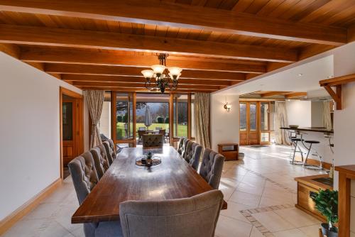 a dining room with a long wooden table and chairs at Manata Homestead & Lodge in Queenstown