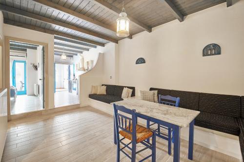 a dining room with a table and chairs and a couch at Kerame Studios & Apartments in Évdhilos