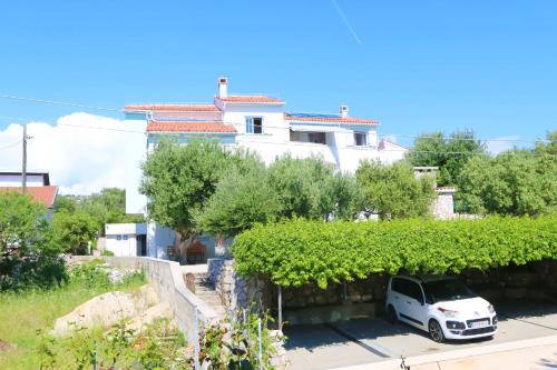 a white car parked in front of a house at Apartments Delminium in Lun