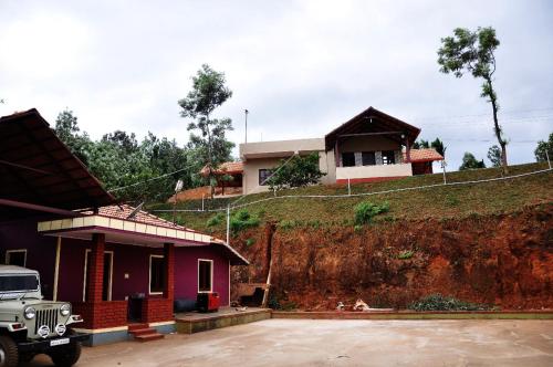 a house with a truck parked in front of it at Vamoose Kaddu Kallu in Kalasa