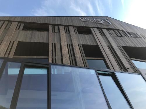 a building with a clars sign on the side of it at Hotel Chalet S - Dolomites Design - adults recommended in Selva di Val Gardena