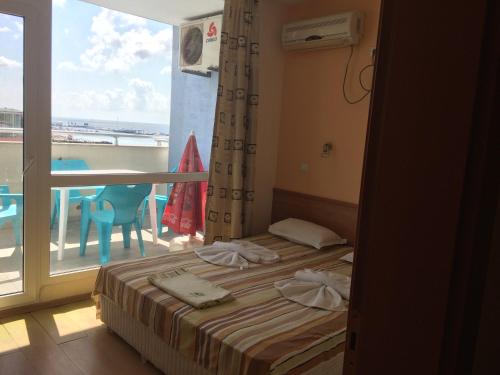 a bedroom with a bed and a balcony with a view at Апартамент с две спални в комплекс Лъки 2 Свети Влас in Sveti Vlas