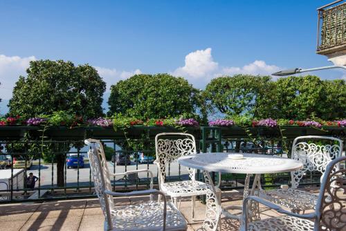 a patio with a table and chairs and flowers at Albergo Pesce D'oro in Verbania