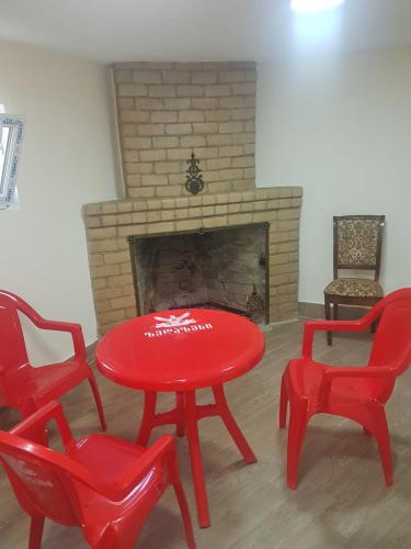 a red table and chairs in front of a fireplace at Green Palma in Kutaisi