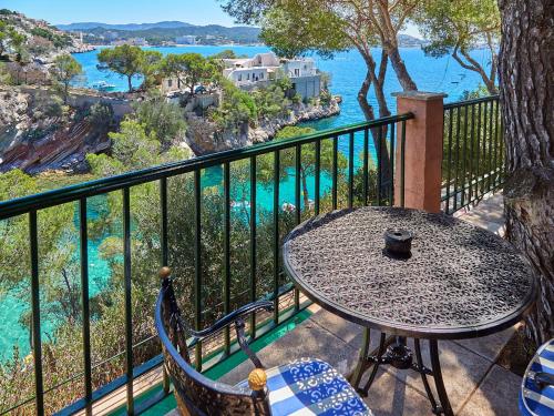 a table and chairs on a balcony overlooking the water at Hotel Petit Cala Fornells in Paguera
