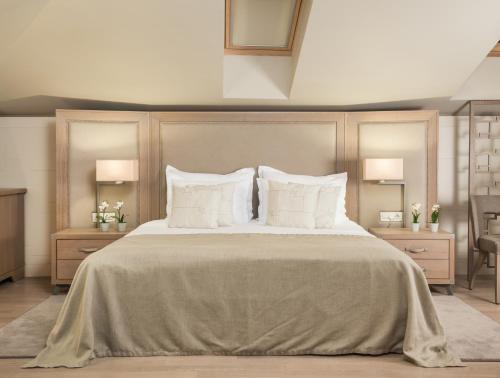 a bedroom with a large bed with white pillows at Art Hotel Kalelarga in Zadar