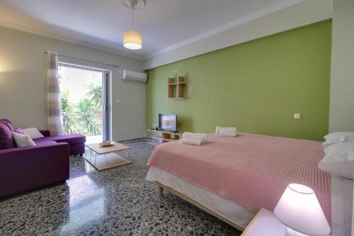1 dormitorio con cama y sofá púrpura en Carpe Diem near the Athens airport, en Markopoulo
