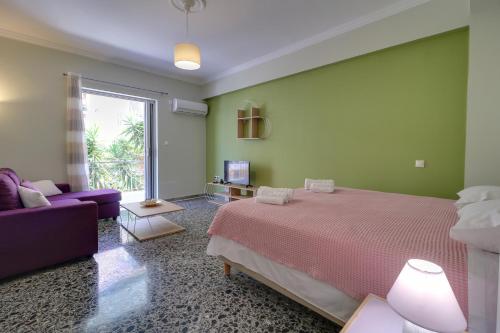 a bedroom with a bed and a purple couch at Carpe Diem near the Athens airport in Markopoulo