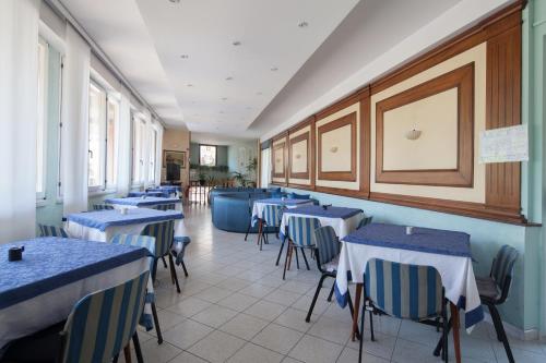 a dining room with blue tables and chairs at Hotel Nella in La Spezia