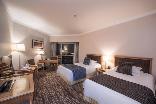 a hotel room with two beds and a desk at Xiyuan Hotel in Beijing