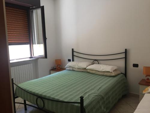 a bedroom with a green bed with two pillows at B&B Le Due Gemme Marsaglia in Marsaglia