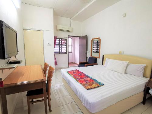 a bedroom with a bed and a desk and a television at Star Lodge in George Town