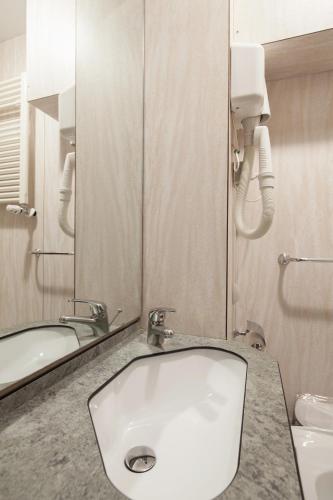a bathroom with a sink and a mirror at Hotel Nella in La Spezia