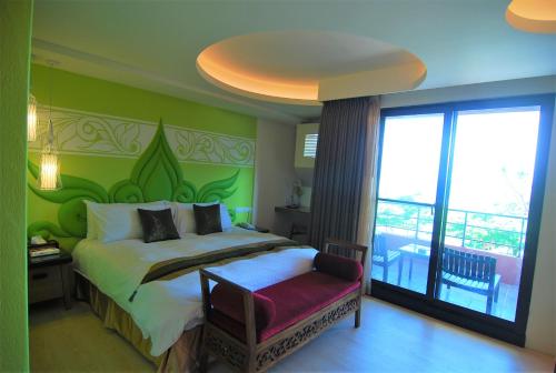 a bedroom with a bed with a green wall at A&L Inn 戀灣旅棧 in Nanwan