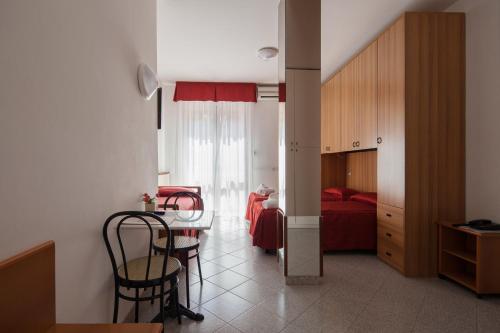 a room with a table and chairs and a bedroom at Hotel Nella in La Spezia