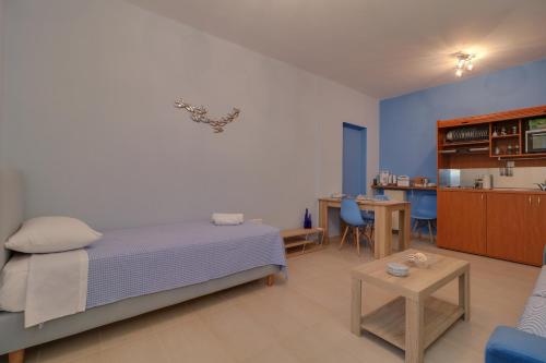a bedroom with a bed and a table and a kitchen at Carpe Diem near the Athens airport in Markopoulo