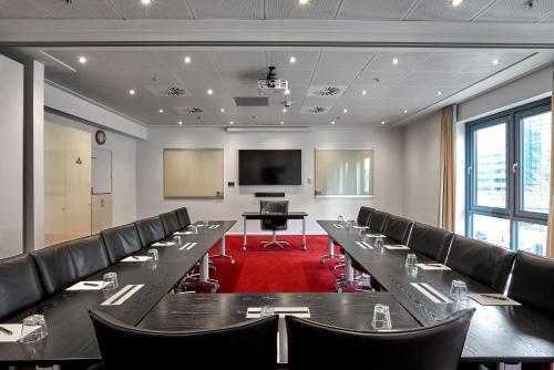 a conference room with chairs and a table and a screen at Copenhagen Island Hotel in Copenhagen