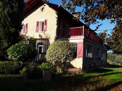 una casa con un balcone rosso nella parte anteriore di Chez Cécile et Jean-No a Gan