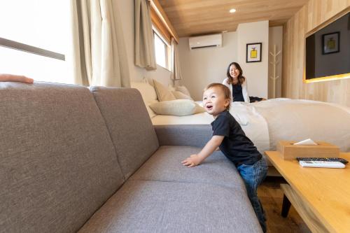 a young boy sitting on a couch in a room at Sakura Cross Hotel Shinjuku East in Tokyo