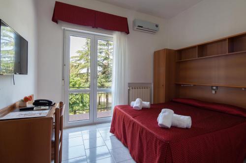 a bedroom with a red bed with towels on it at Hotel Nella in La Spezia