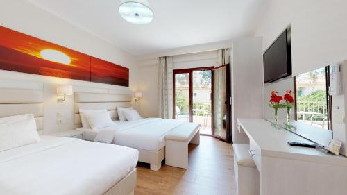 a hotel room with two beds and a television at Valentinos House in Parga