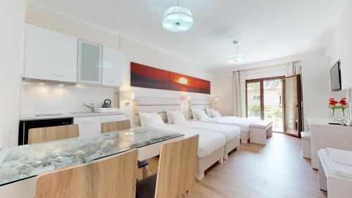 a living room with white furniture and a kitchen at Valentinos House in Parga