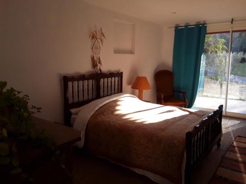 Gan的住宿－Chez Cécile et Jean-No，一间卧室设有一张大床和一个窗户。
