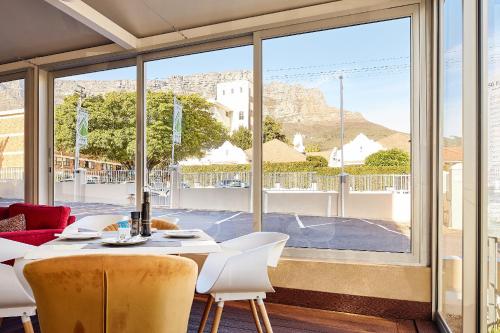 a room with a table and chairs and a large window at First Group Mount Sierra in Cape Town