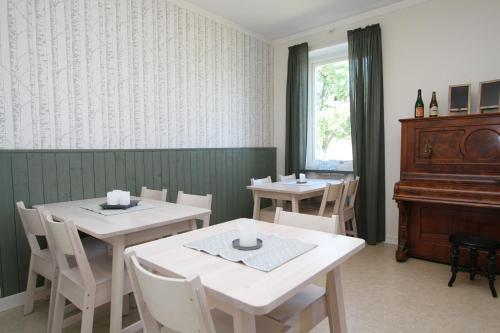 a dining room with two tables and a piano at STF Vandrarhem Blentarp in Blentarp