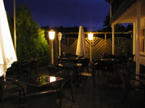 an outdoor patio with tables and chairs at night at Sonneneck in Winterberg