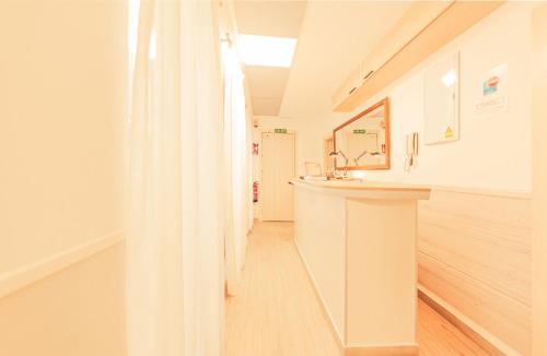 La salle de bains blanche est pourvue d'un lavabo et d'un miroir. dans l'établissement Atocha28, à Madrid