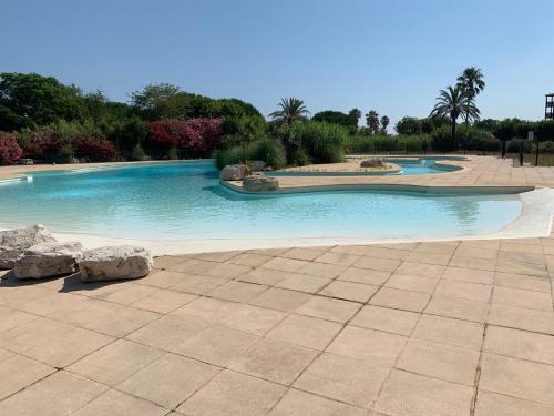 a large swimming pool with rocks in a yard at Appartement 4 personnes, vue mer exceptionnelle sur le golf de St Tropez in Saint-Tropez