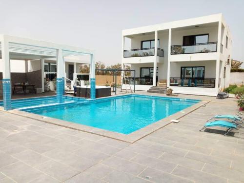 a large swimming pool in front of a building at Bungalow Thaï vip jacuzzi interne in Ngaparou