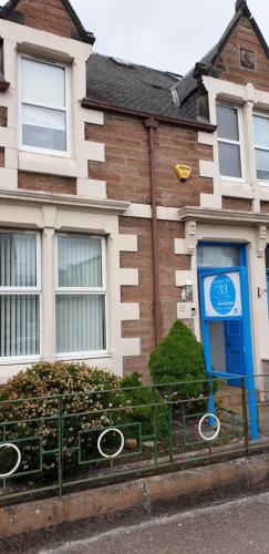 a house with a blue door in front of it at Dunskaith Villa in Inverness