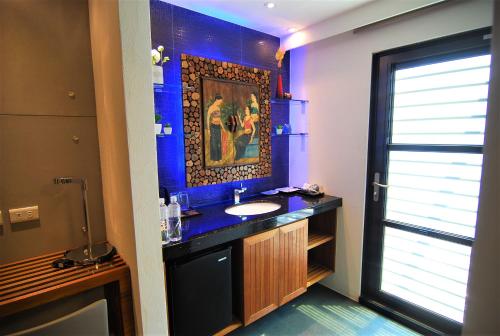 a bathroom with a sink and a blue wall at A&L Inn 戀灣旅棧 in Nanwan