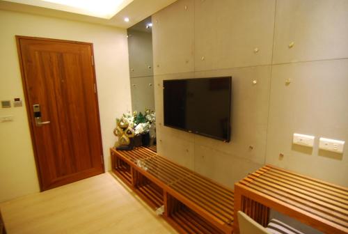 a living room with a flat screen tv on a wall at A&L Inn 戀灣旅棧 in Nanwan