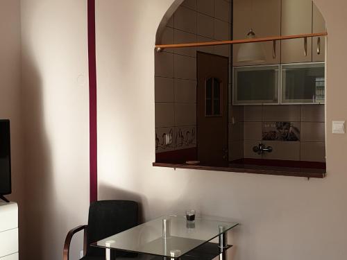 une salle à manger avec une table en verre et un miroir dans l'établissement Apartament MINI CENTRUM, à Szczecin