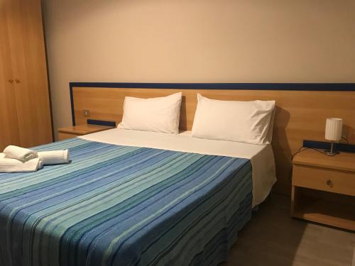 a hotel room with a bed with a phone on it at Country House Paola in Marina di Gioiosa Ionica