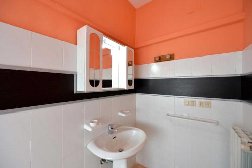 an orange and white bathroom with a sink and a mirror at Agriturismo Santa Chiara in Alezio