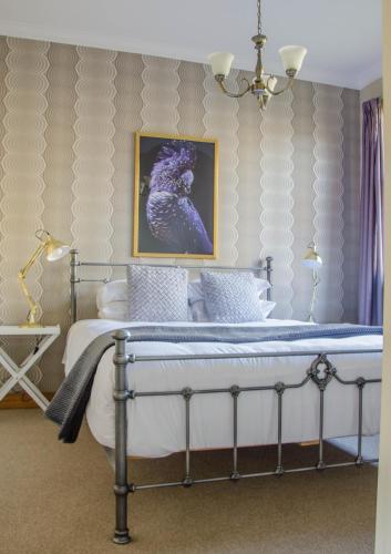 a bedroom with a bed with a picture on the wall at Mataura Lodge Athol in Athol