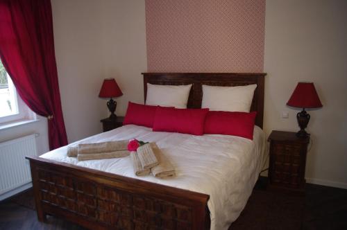 a bedroom with a large bed with red pillows at Villa Wilmarie in Rottweil