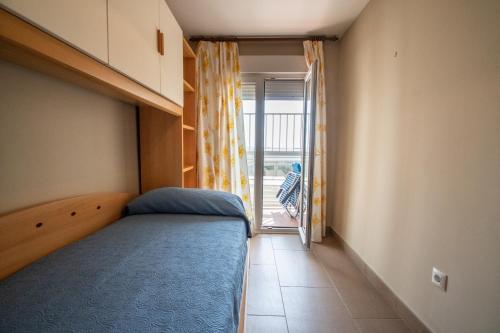 a small bedroom with a bed and a balcony at Apartamento Paseo Maritimo 27 in Cádiz