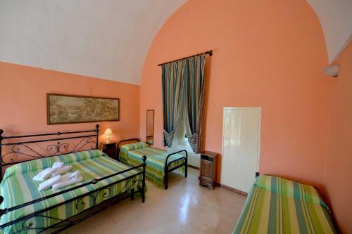 a bedroom with two beds and a chair in it at Agriturismo Santa Chiara in Alezio