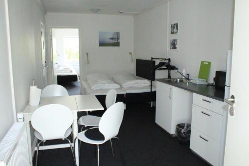 um quarto com uma mesa e cadeiras e uma cama em Motel Poppelvej em Herning